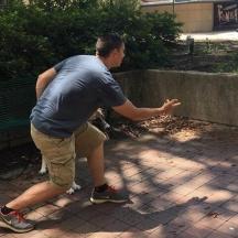un home està dret al costat d'un banc del parc