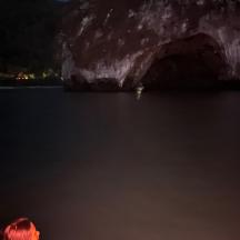 una barca in acqua di fronte a una formazione rocciosa