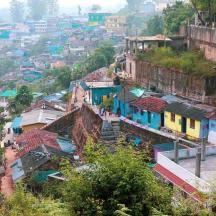 a group of buildings on a hill with a city