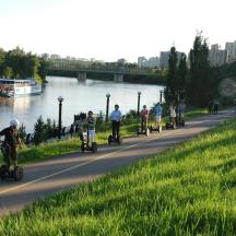 un grup de persones amb patinets per un camí al costat d'un riu