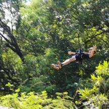 a woman is hanging from a rope in the air