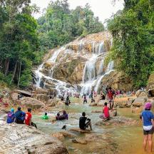 a group of people in a river with a waterfall