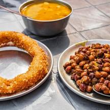 a table with two plates of food and a pretzel