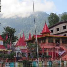 a building with red roofs on the water next to a building