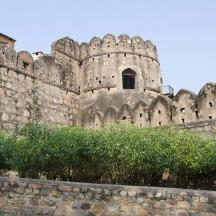 an old castle with a stone wall and some bushes