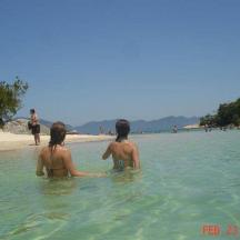two people sitting in the water at the beach