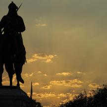 a statue of a man on a horse at sunset