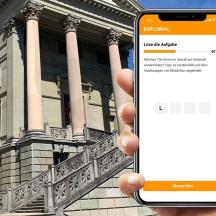 una persona que sosté un telèfon mòbil davant d'un edifici