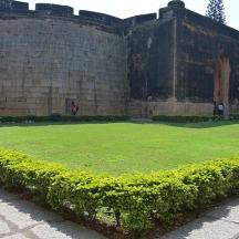 a large grassy area in front of a wall