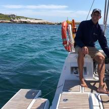 ein Mann sitzt auf der Vorderseite eines Bootes im Wasser