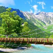 eine Brücke über einen Fluss mit Bergen im Hintergrund