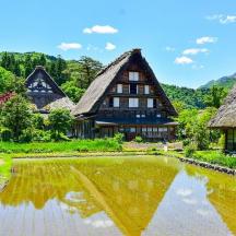 ein großes Haus mit einem Teich davor