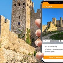 eine Person mit einem Mobiltelefon vor einem Schloss
