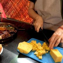 a person cutting cheese on a blue plate