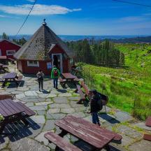 a group of people standing around a building with picnic tables