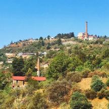 a house on top of a hill with a factory