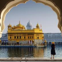 a woman standing in front of a golden temple