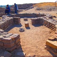 people are standing around a stone building in the desert