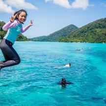 a woman jumping off of a boat in the water