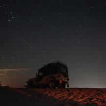 sebuah trak diletakkan di atas pasir di bawah langit berbintang