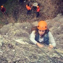 en kvinde i en orange hjelm liggende på nogle klipper
