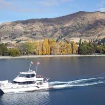 a white boat on the water with mountains in the background