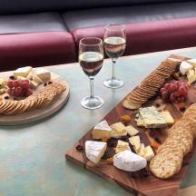 a table with wine glasses and cheese and crackers
