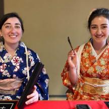 two women are posing for a picture at a table