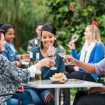 a group of people sitting at a table drinking wine