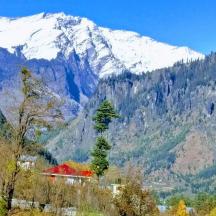 a snow covered mountain with a house in the foreground