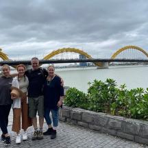a family posing for a picture in front of a bridge