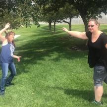 twee meisjes spelen met een frisbee in een park