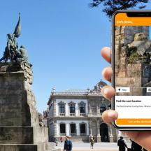en person, der tager et billede af en statue foran en bygning