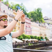 携帯電話で街の写真を撮っている男性