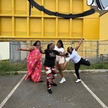 a group of women dancing in a parking lot