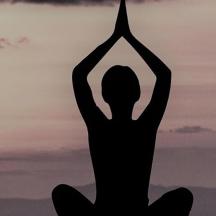 eine Frau macht eine Yoga-Pose vor dem Sonnenuntergang