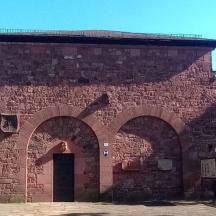 a brick building with a door and two arches