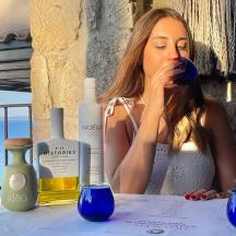 a woman sitting at a table with a bottle of wine