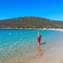 un home dret a l'aigua a la platja