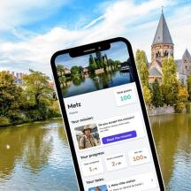 a cell phone in front of a river with a castle