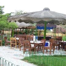 a group of tables and chairs under a large umbrella