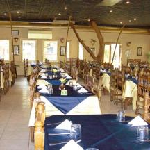 a dining room with blue tables and chairs with people sitting at them