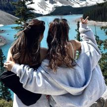 dua wanita berdiri di atas gunung melihat tasik