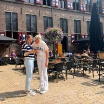 two women standing next to each other in a courtyard