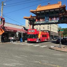 a red double decker bus driving down a city street