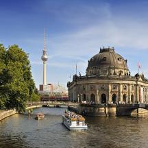 a boat in a river with a building and a bridge