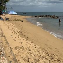 a beach with footprints in the sand and the ocean