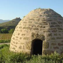 a stone dome with a door in a field