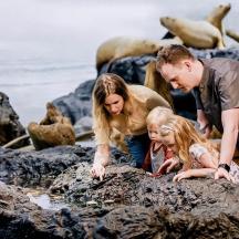 en familie kigger på klipper på stranden