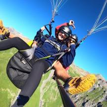 a man riding a paraglider in front of a mountain